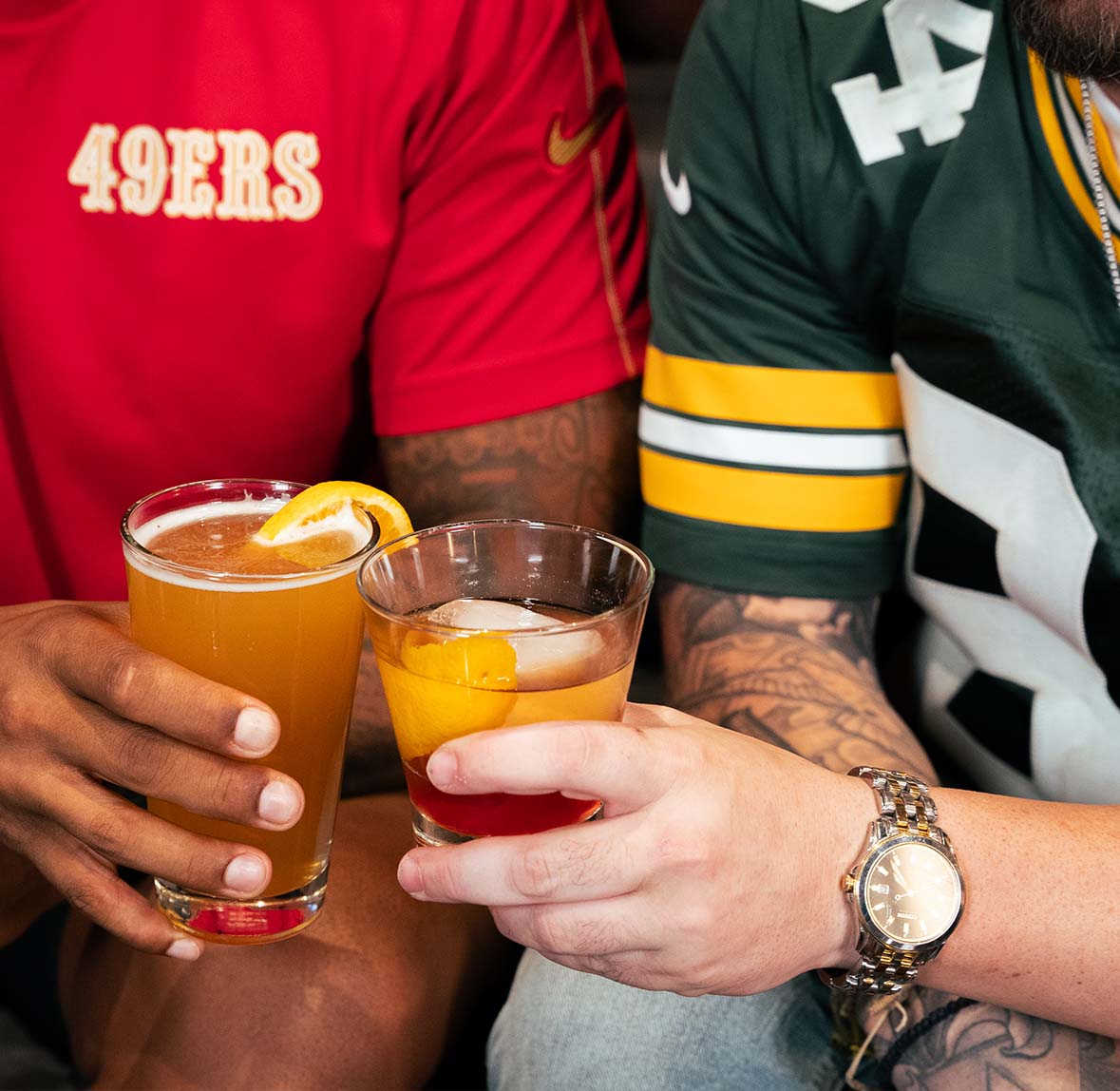 49ers and Greenbay jersey hands holding beer and cocktail